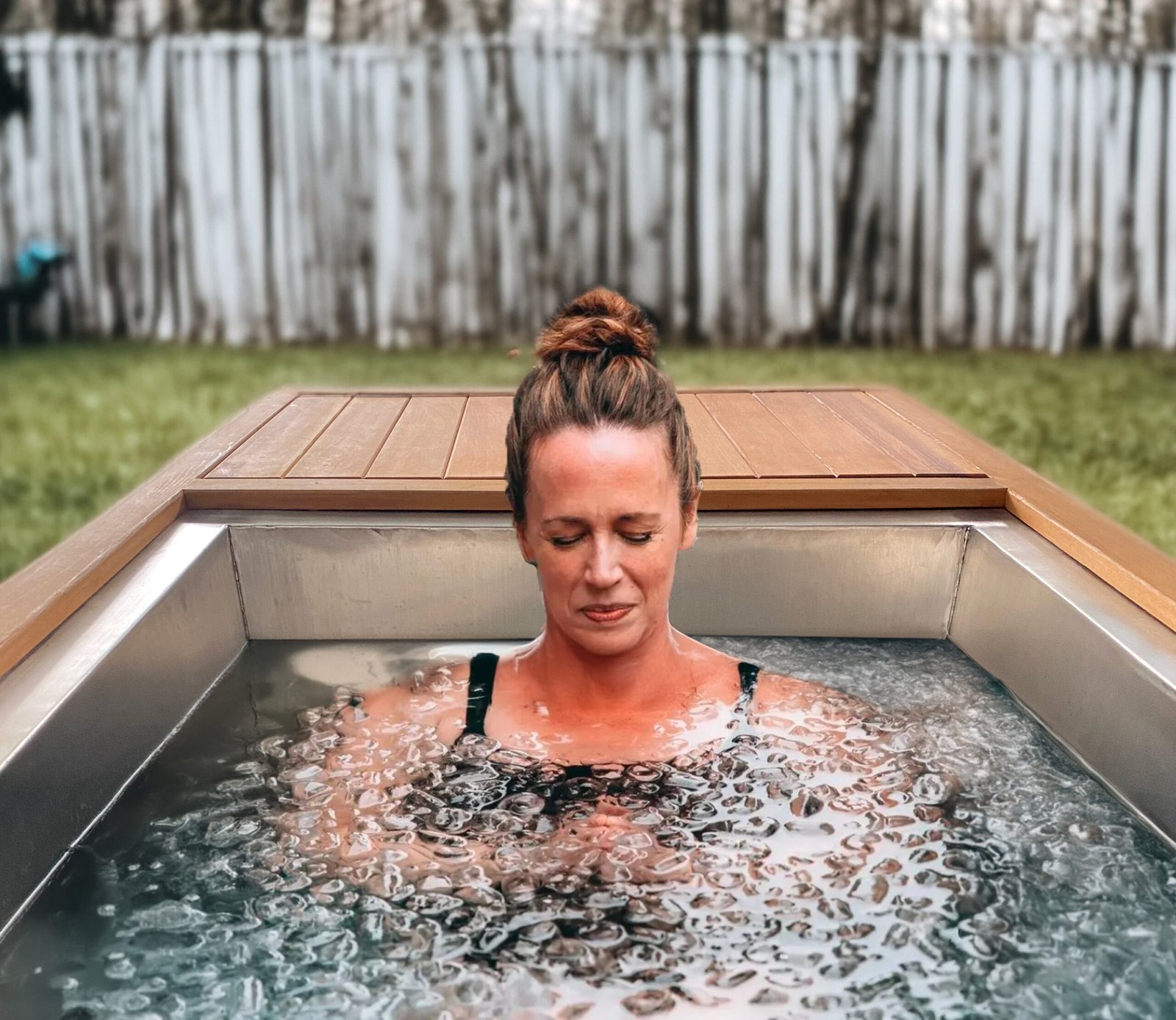 Woman relaxing in ice bath tub during cold therapy session