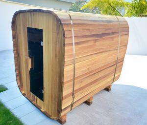 Square red cedar sauna positioned in a sunny garden courtyard