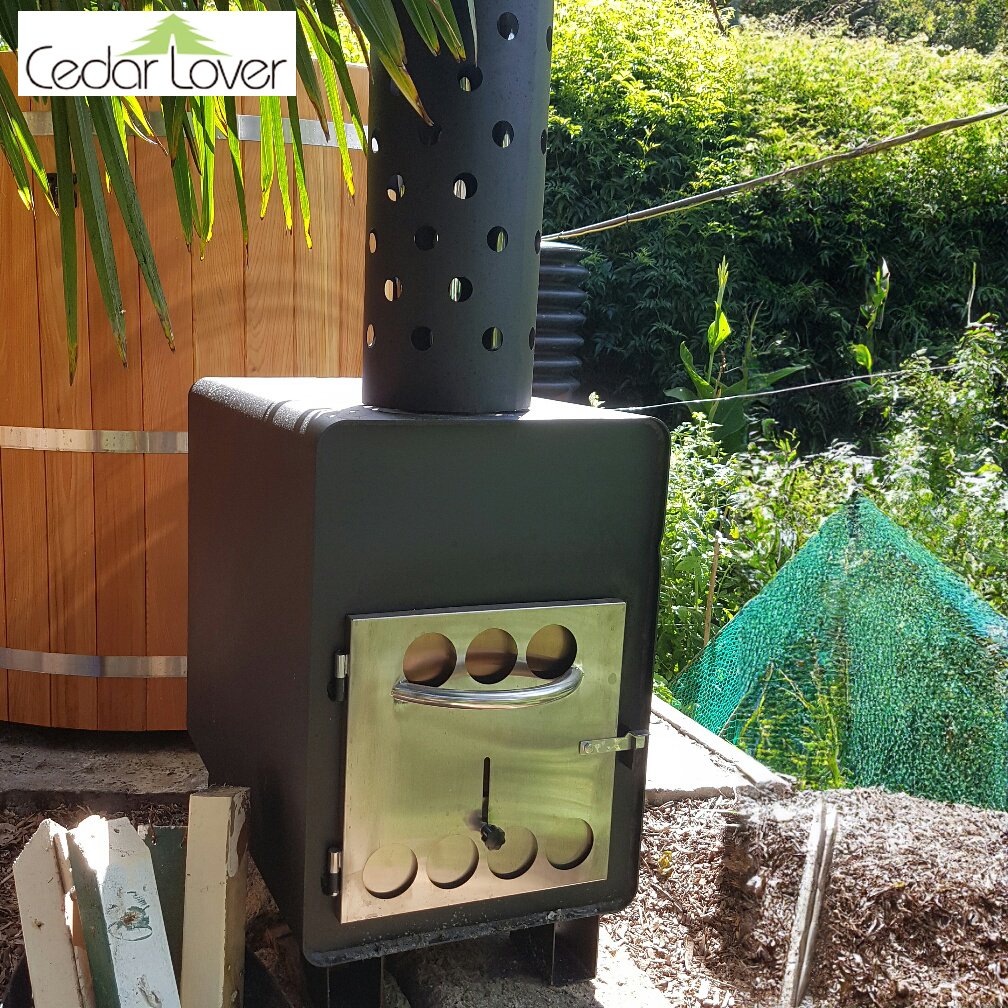 Wood-fired stove next to hot tub, surrounded by green plants