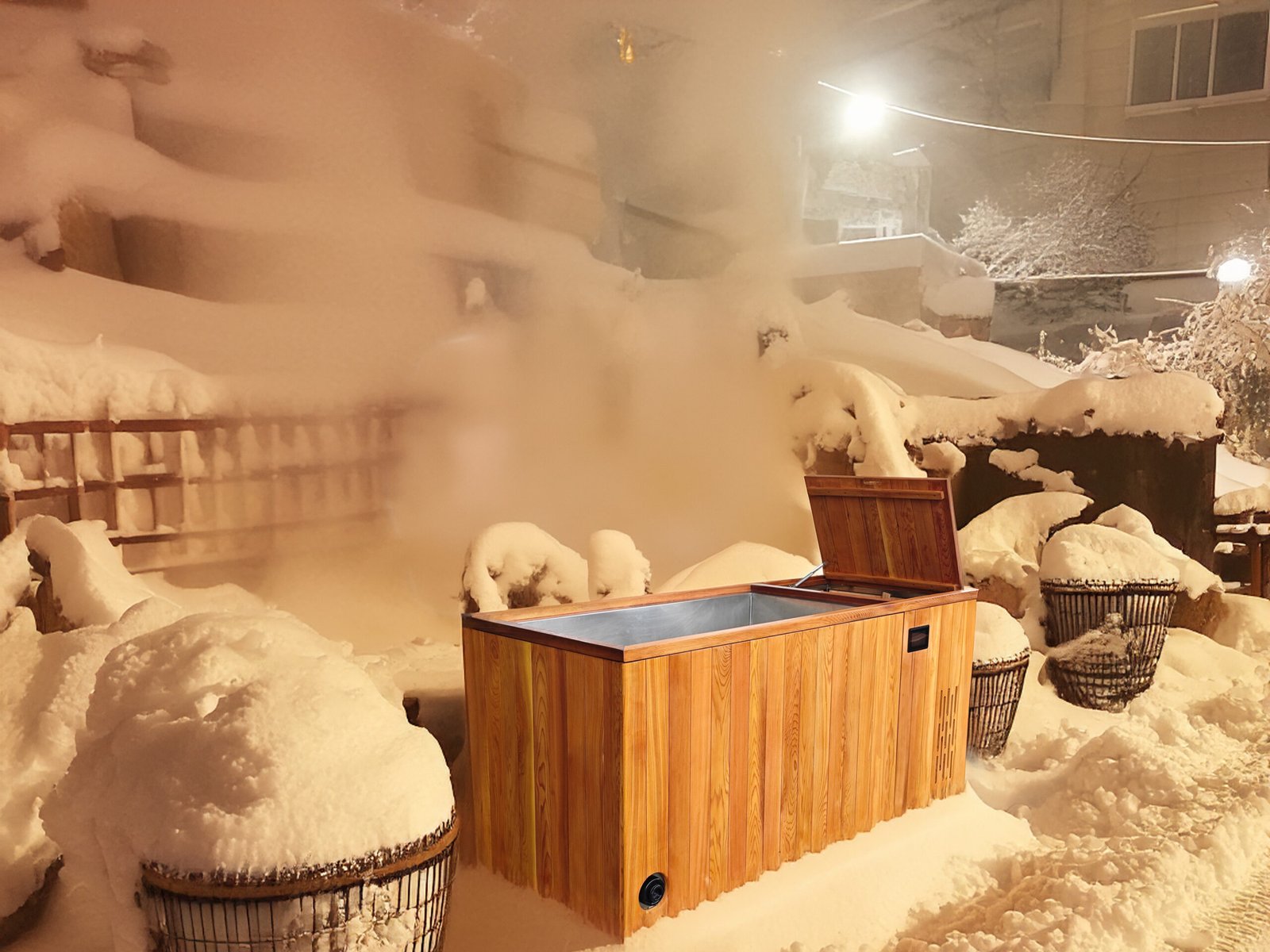 Red cedar ice bath tub in the snow with white steam around it