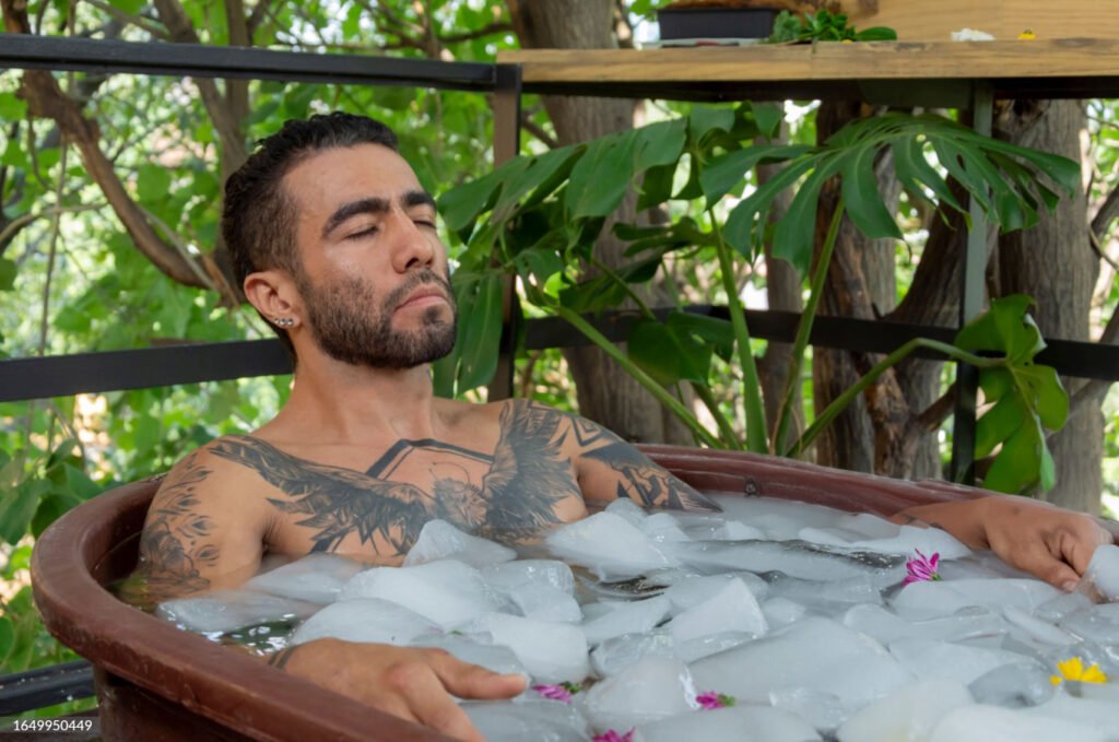 Person immersed in an ice bath filled with ice cubes for therapy