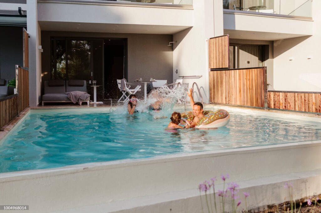 Multi generational family playing together in backyard swimming pool   joyful summer water activities and healthy lifestyle moments