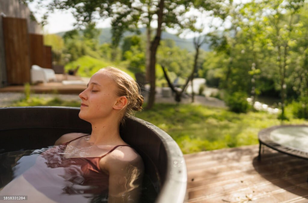 2 Cedar Lover Person leaning on the edge of the tub with water up to her shoulders in a relaxing soak