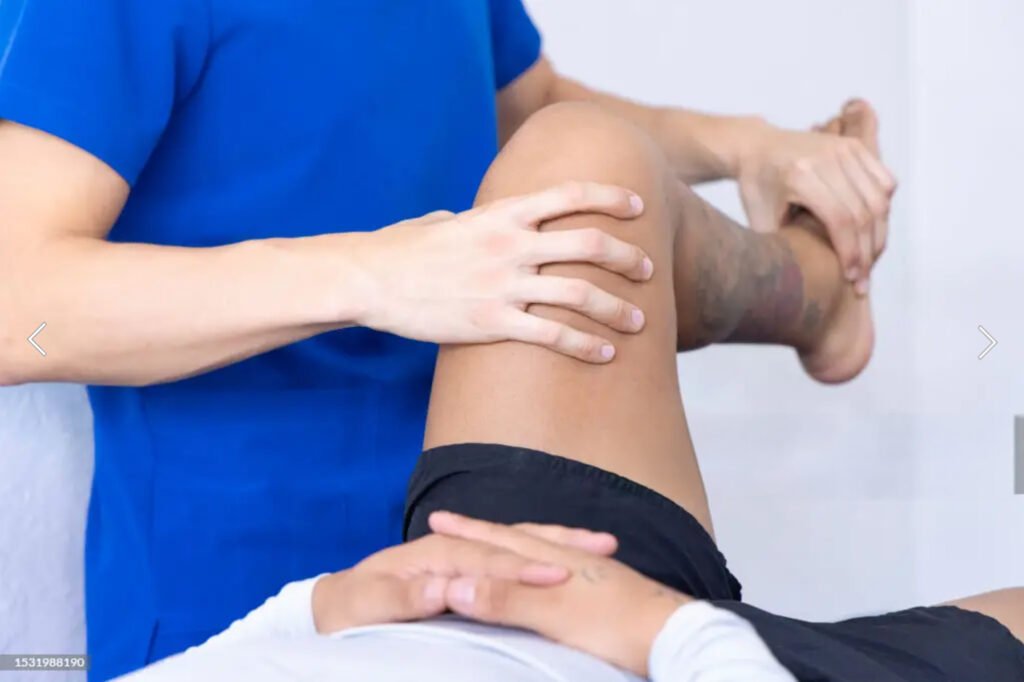 2 Cedar Lover A person lying down while another individual bends their lower leg for muscle recovery