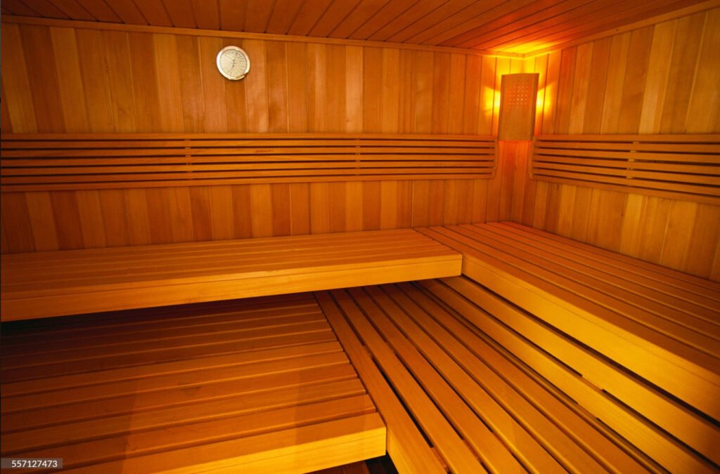 Well-arranged sauna with a clock, soft lighting, and clean benches.